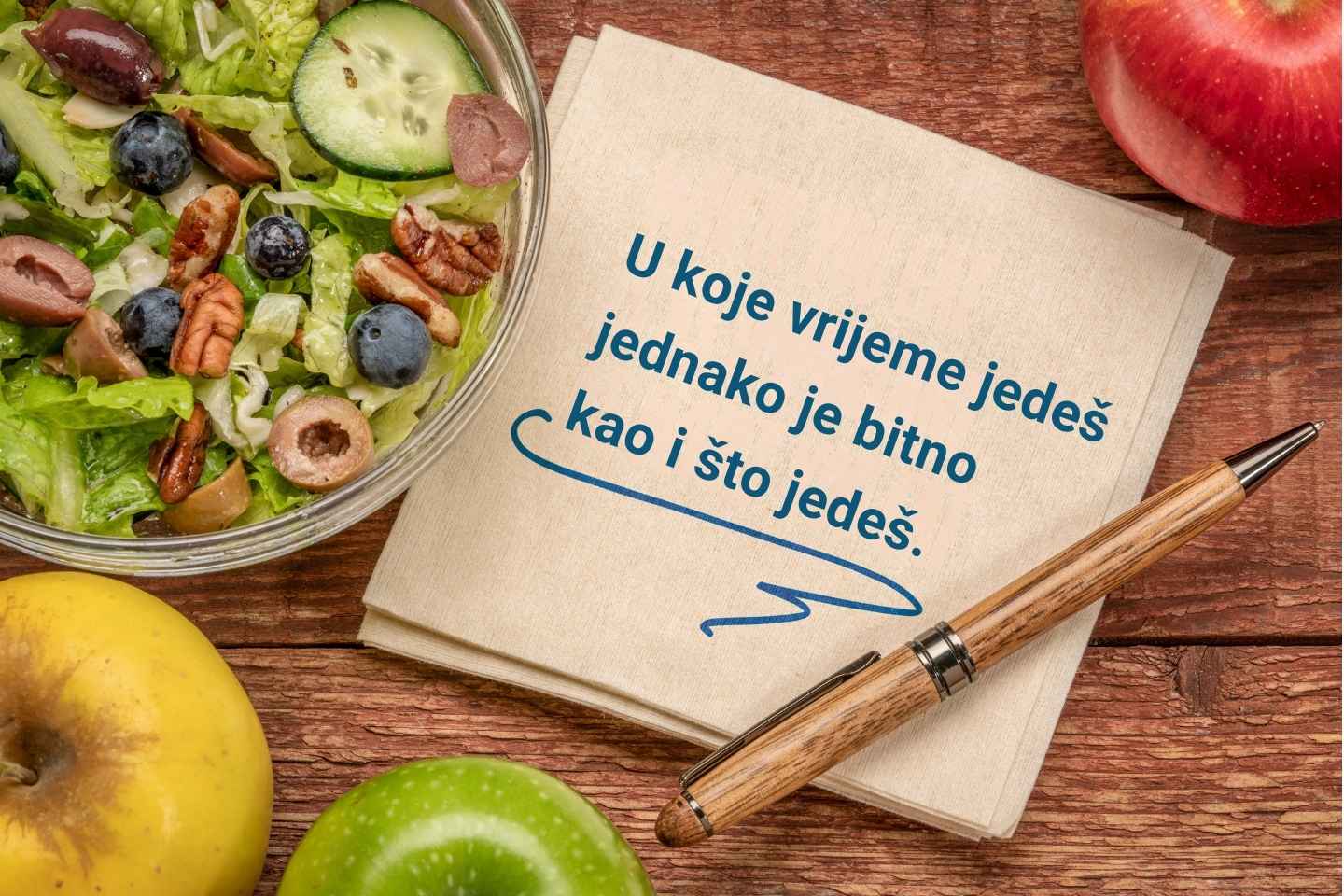 Povremeni post - inspirativna poruka na ubrusu okruženom zdravom salatom i jabukama.