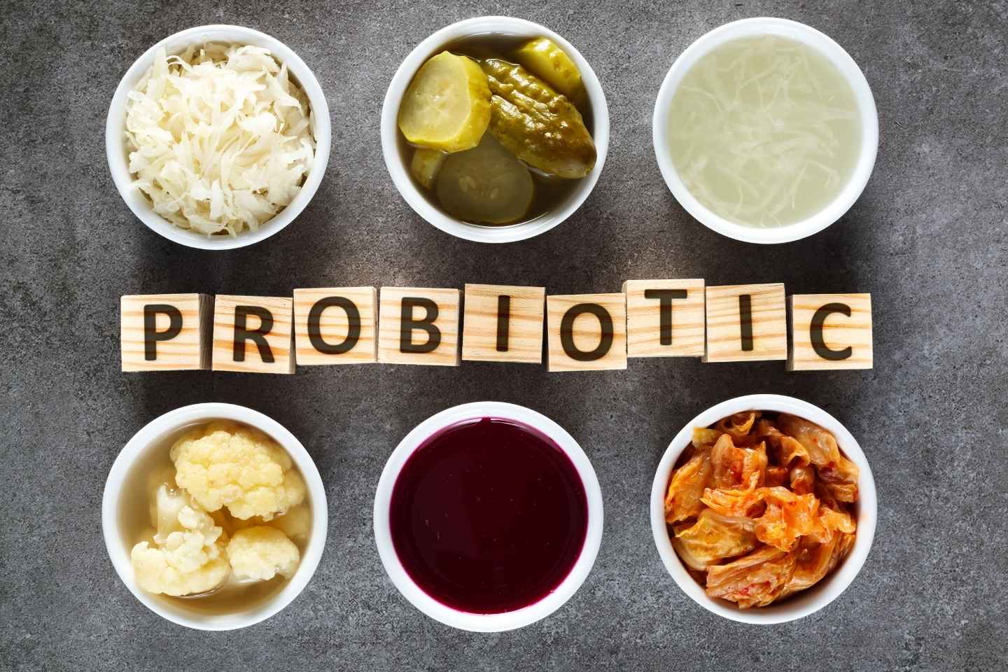 Slika fermentirane hrane u zdjelicama, prirodni probiotici za zdrava crijeva - kiseli kupus, ukiseljeni cvjetača, ukiseljeni krastavac, sok od kiselog kupusa, kimchi, kvasac od cikle.